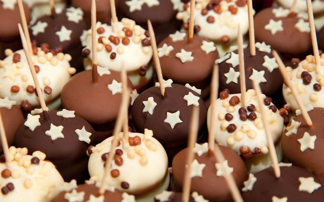 Una caja de chocolate con piruletas de chocolate y arte visual